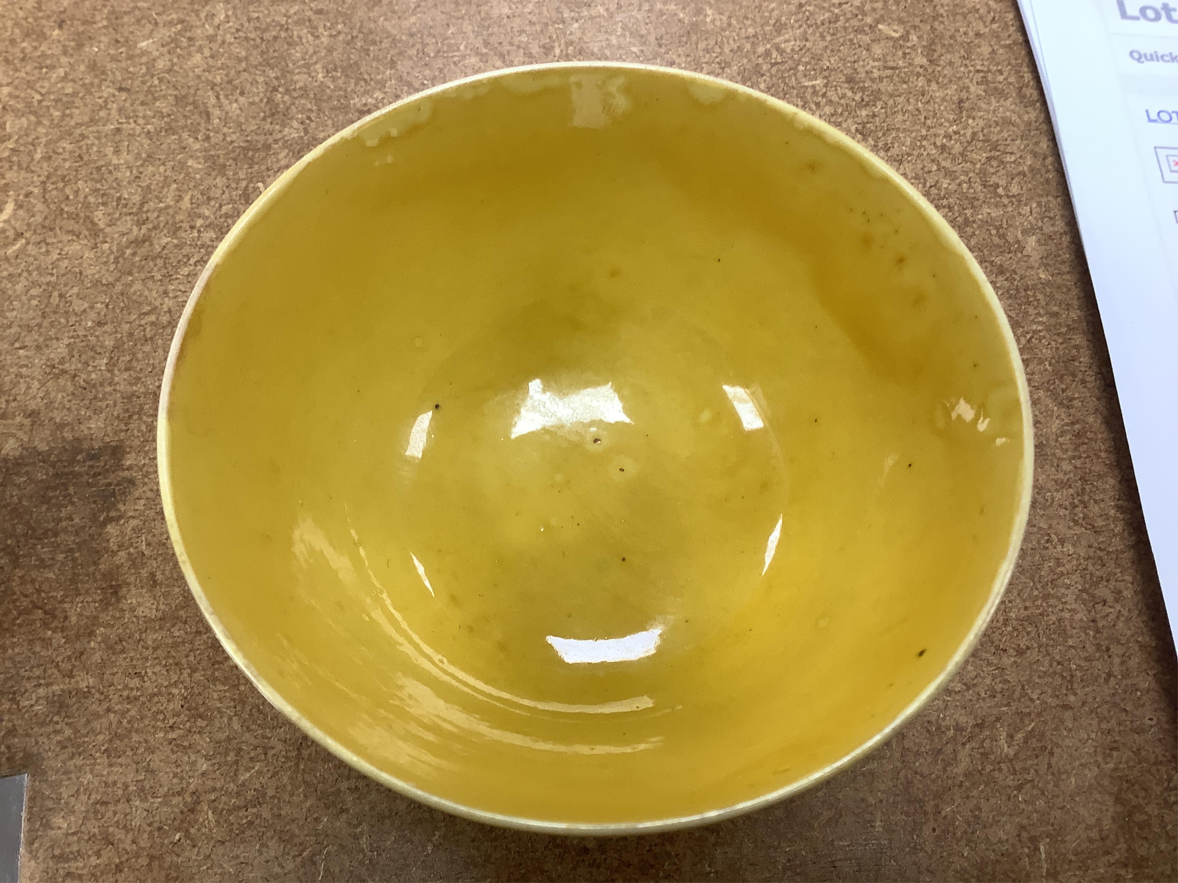 A Chinese yellow glazed teabowl on hardwood stand, 9cm diameter. Condition - fair